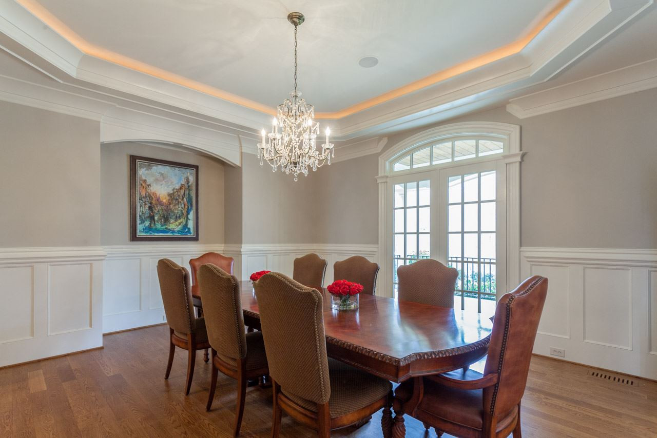 3032 Cone Manor Lane Raleigh, NC 27613 - Photo 12 of 30 The dining room offers hardwood floors, furniture alcove, trey ceiling with ambient lighting, wainscoting, cove crown molding, crystal chandelier, distributed audio and double French-style floor-to-ceiling windows. Well-Appointed Dining Room