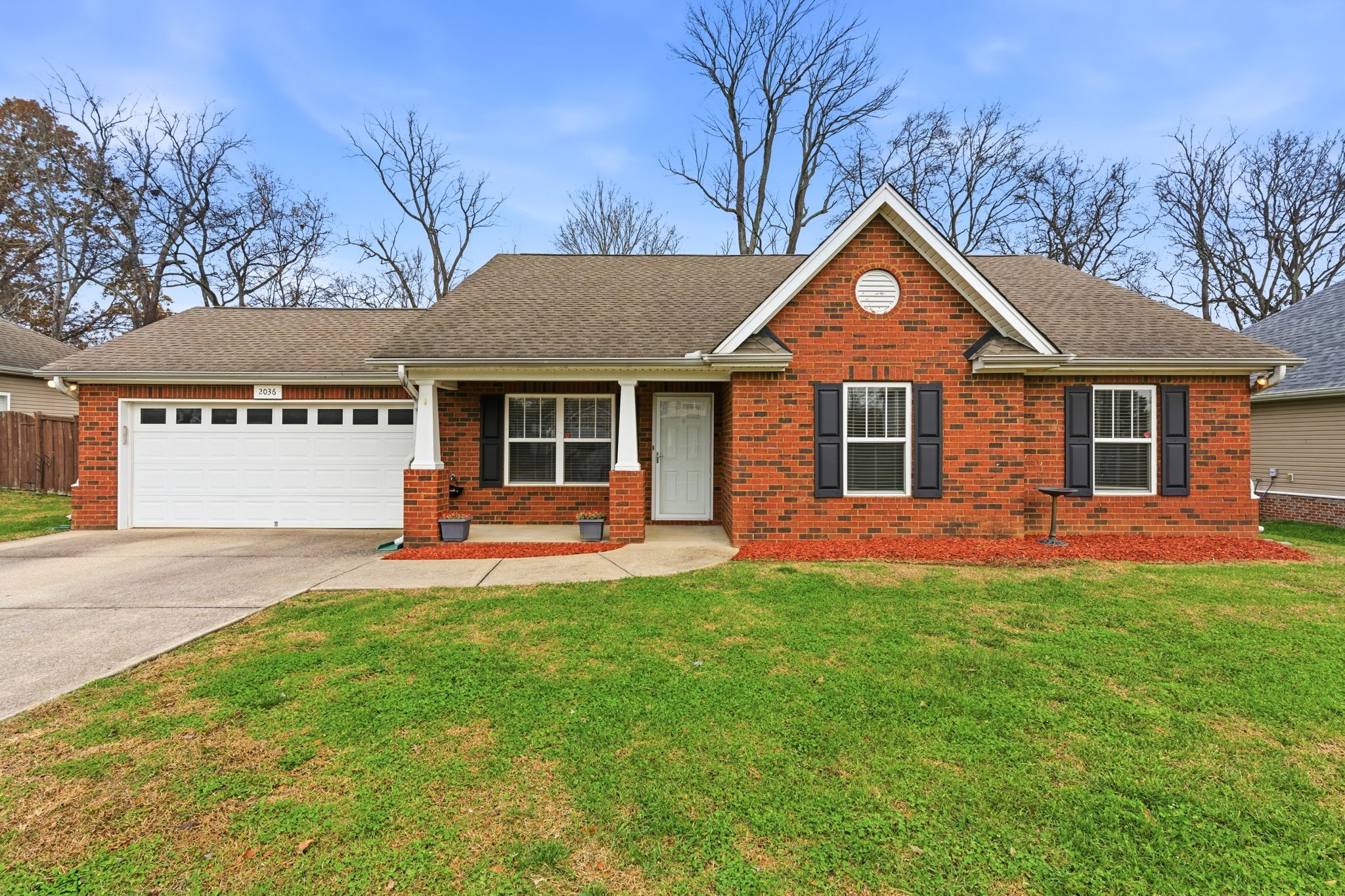a front view of a house with a garden and yard
