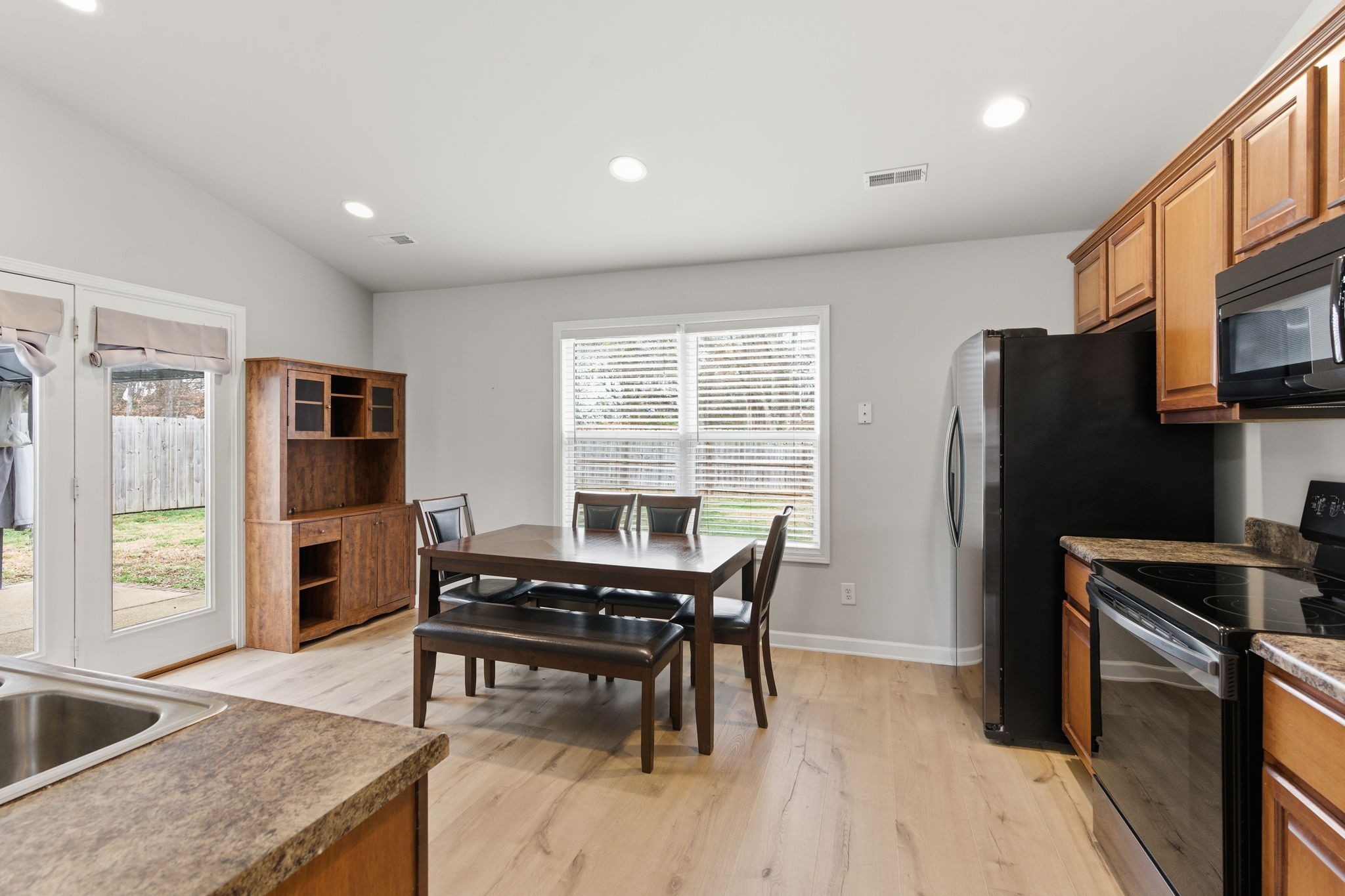 2036 Sparrow Street Spring Hill, TN 37174 - Photo 7 of 25 a kitchen with a table chairs refrigerator and microwave