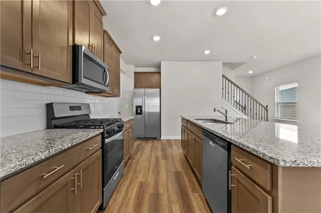 a kitchen with stainless steel appliances granite countertop a stove a refrigerator and a microwave