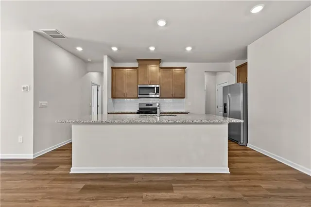 a kitchen with stainless steel appliances granite countertop a stove a sink and a granite counter tops