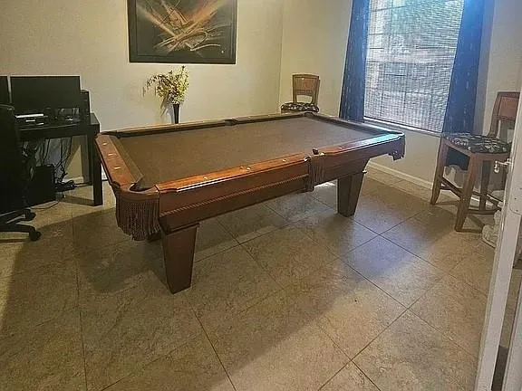 a room with pool table and windows
