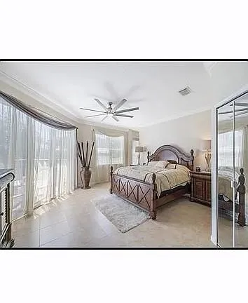 a bedroom with a bed and a large window