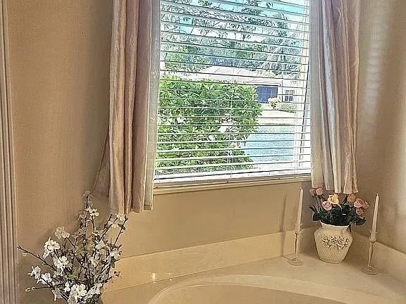a white bath tub sitting in a bathroom next to a window