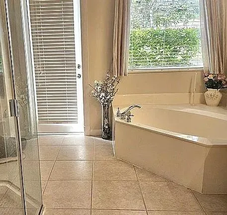 a white bath tub sitting in a bathroom next to a window