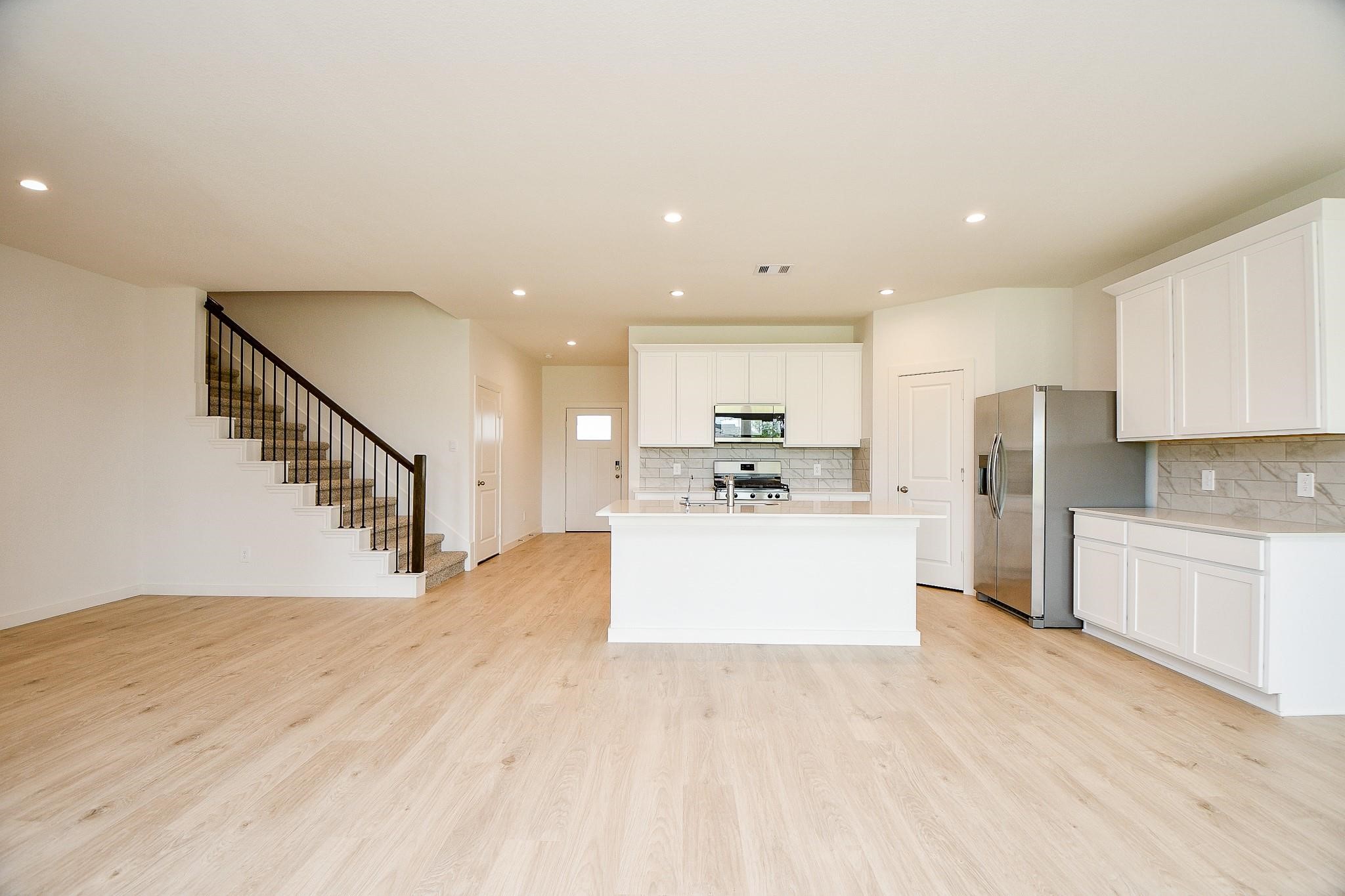 3930 Winterbourne Way Fulshear, TX 77441 - Photo 3 of 28 a view of kitchen with refrigerator microwave and stove top oven