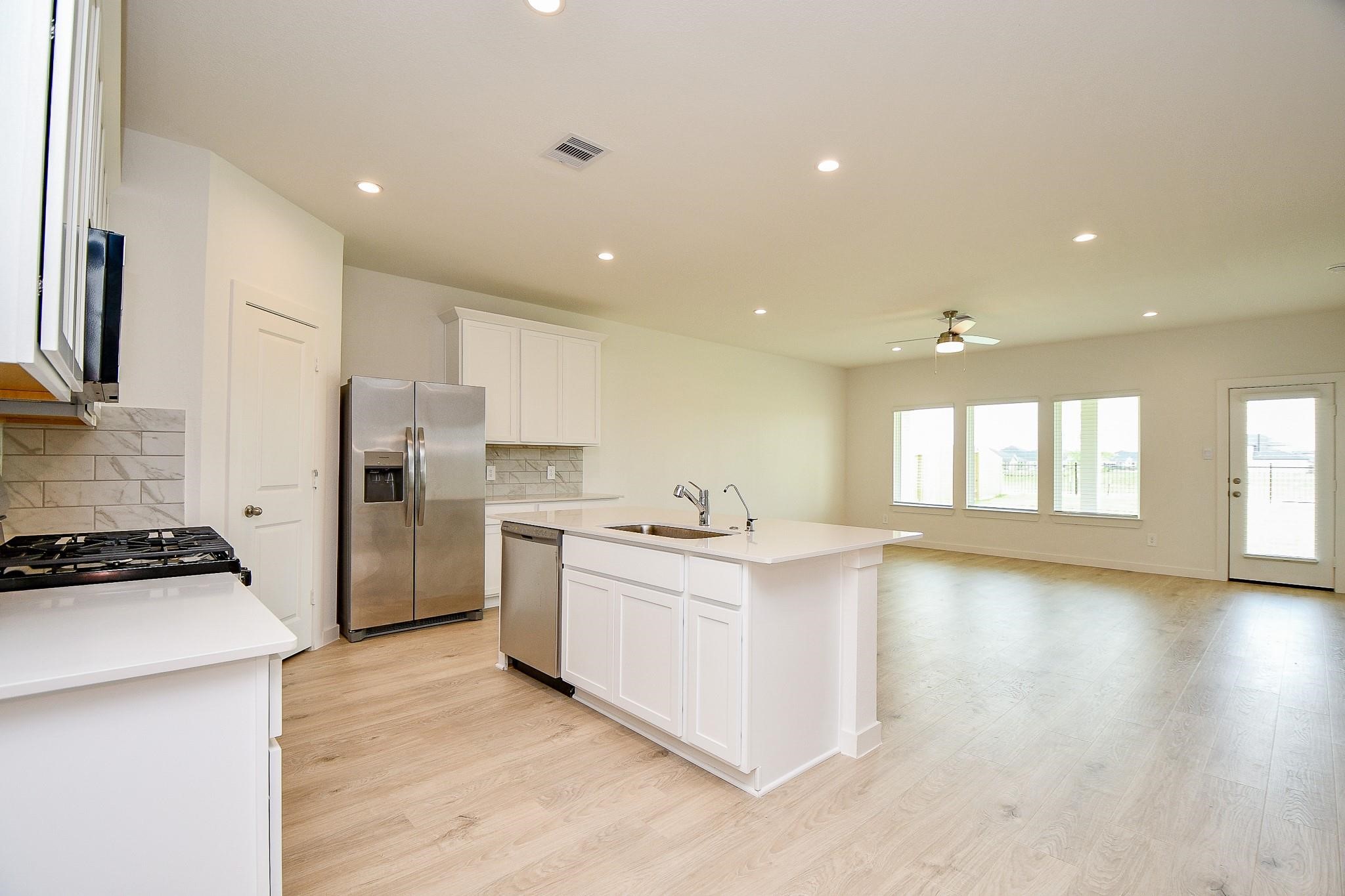 3930 Winterbourne Way Fulshear, TX 77441 - Photo 4 of 28 a kitchen with a refrigerator and a stove top oven