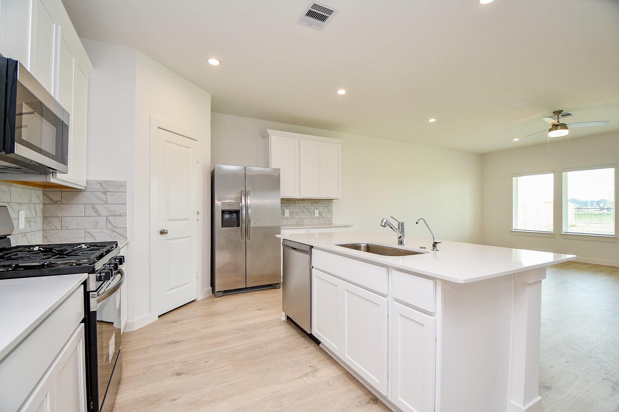 3930 Winterbourne Way Fulshear, TX 77441 - Photo 5 of 28 a kitchen with a sink stove and refrigerator