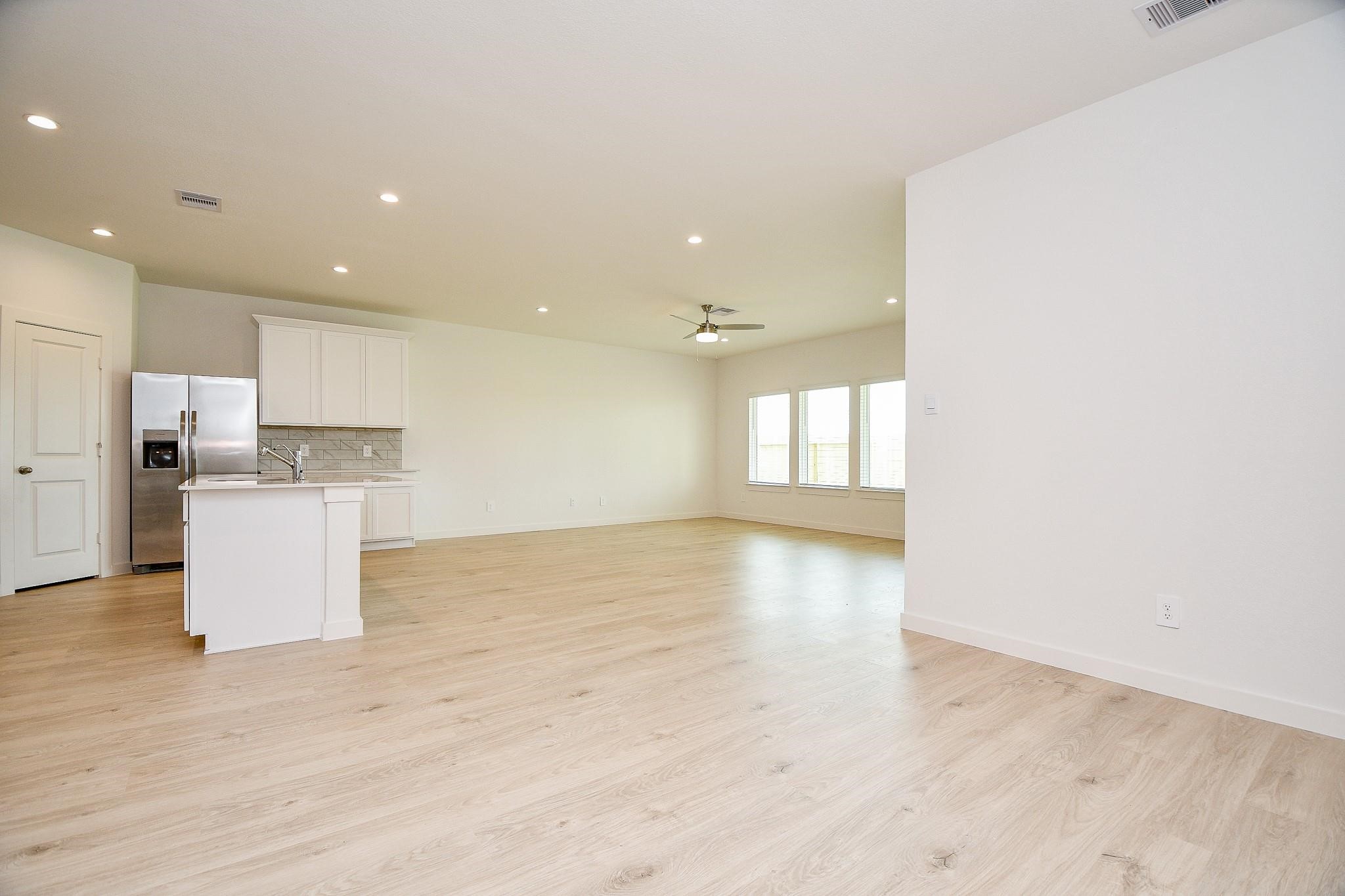 3930 Winterbourne Way Fulshear, TX 77441 - Photo 8 of 28 a view of kitchen with kitchen island a sink wooden floor and a refrigerator