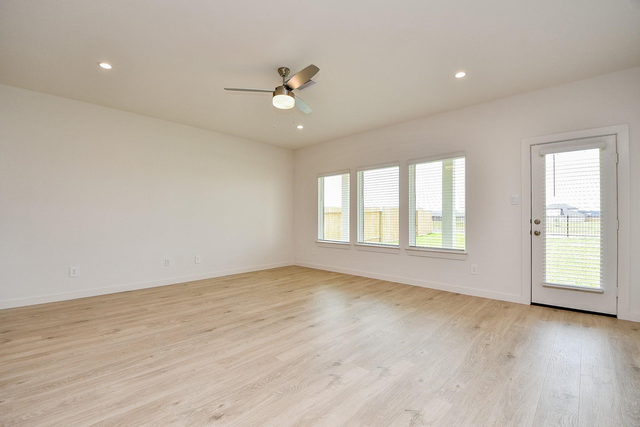 3930 Winterbourne Way Fulshear, TX 77441 - Photo 9 of 28 an empty room with wooden floor and windows
