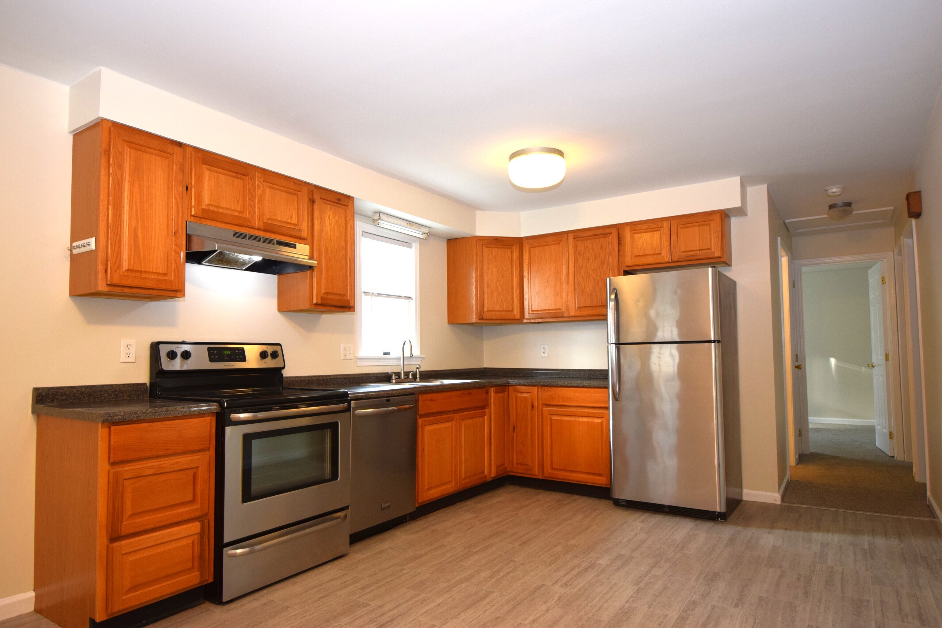 7 Shelby Circle Killingly, CT 06241 - Photo 8 of 16 a kitchen with stainless steel appliances granite countertop a refrigerator a sink dishwasher a stove with wooden cabinets and floors