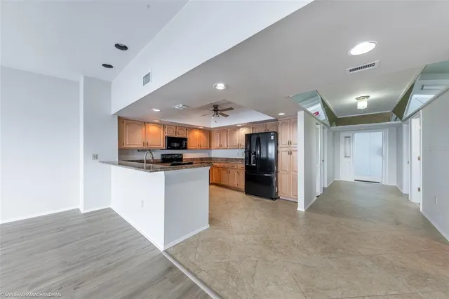 a kitchen with stainless steel appliances granite countertop a refrigerator a sink a stove top oven and a refrigerator