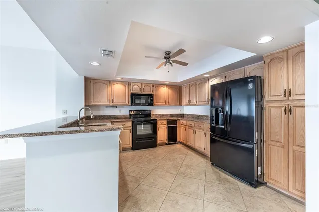 a kitchen with stainless steel appliances granite countertop a stove refrigerator sink and dishwasher