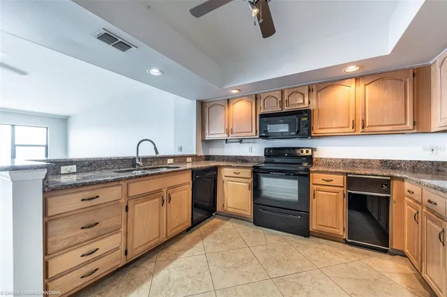 a kitchen with granite countertop a refrigerator stove and microwave