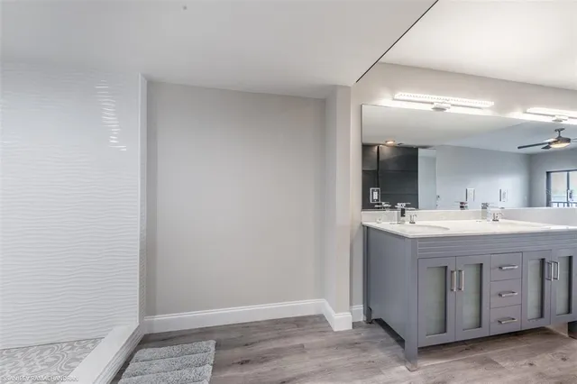 a view of a kitchen center island wooden floor and stainless steel appliances