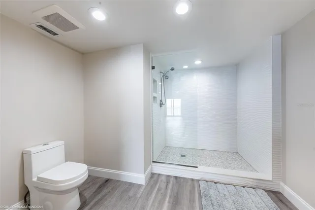 a bathroom with a granite countertop shower and a toilet