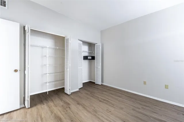 an empty room with wooden floor and ceiling fan