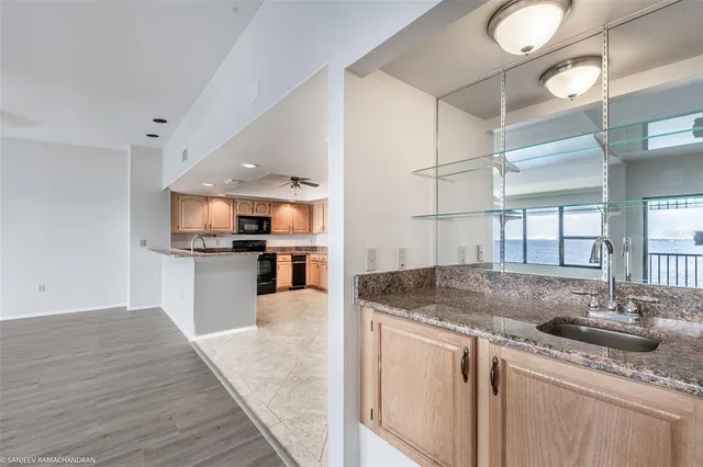 an empty room with wooden floor ceiling fan and windows