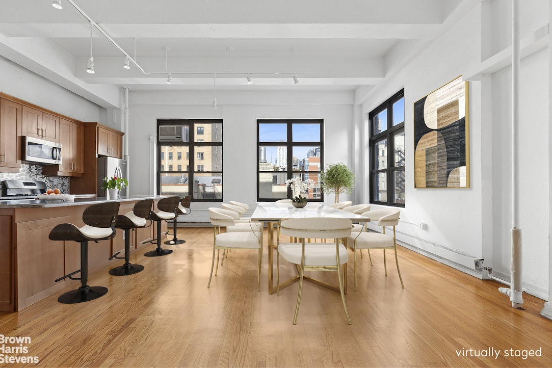 161 West 15th Street, Unit 6B Manhattan, NY 10011 - Photo 4 of 14 a living room with couches a coffee table and kitchen view with wooden floor