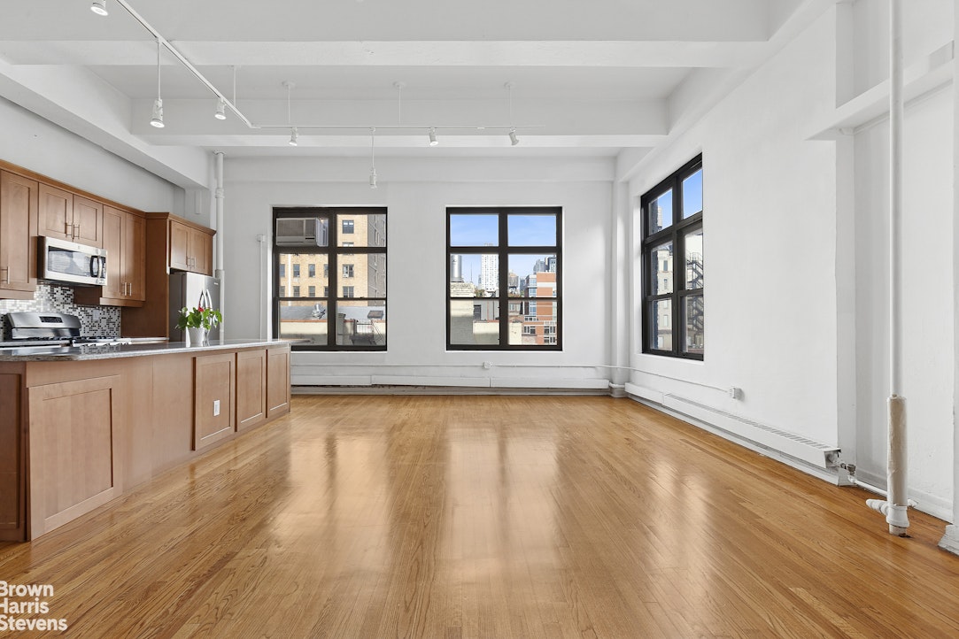 161 West 15th Street, Unit 6B Manhattan, NY 10011 - Photo 5 of 14 a view of an empty room with window and wooden floor