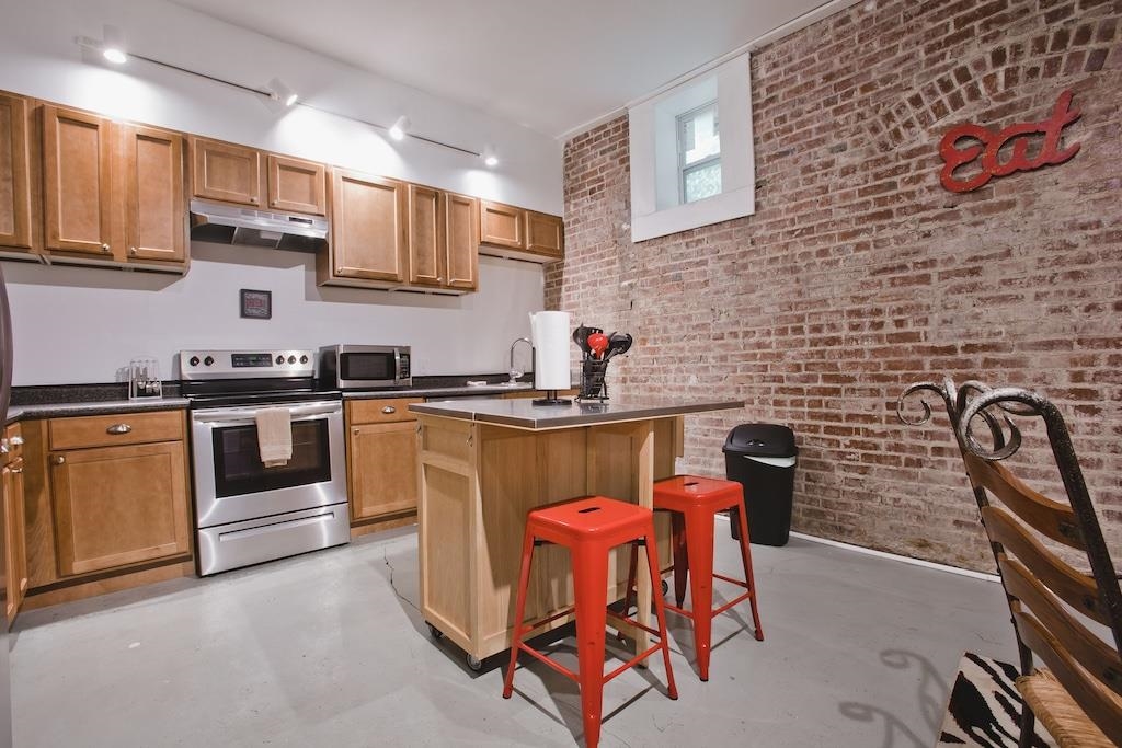 179 Vance Avenue Memphis, TN 38103 - Photo 18 of 25 a kitchen with stainless steel appliances a stove a sink a microwave a dining table and chair