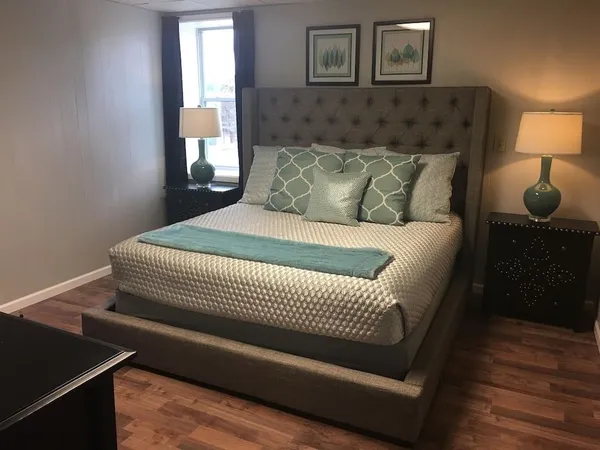 a bedroom with a bed and wooden floor