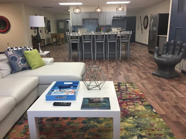 a living room with furniture a flat screen tv and kitchen view