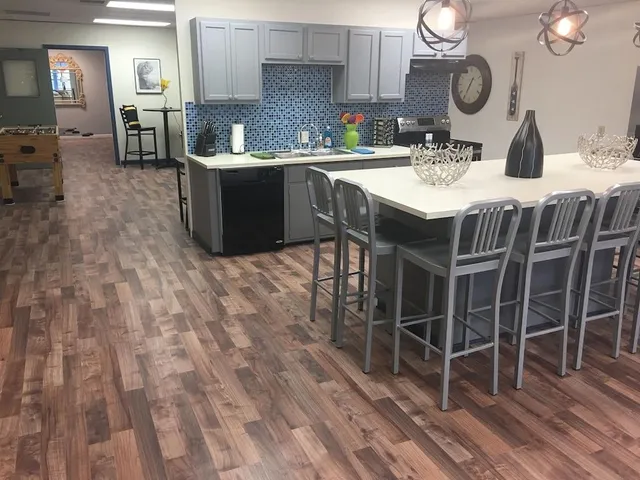 a kitchen with kitchen island granite countertop a sink cabinets and stainless steel appliances