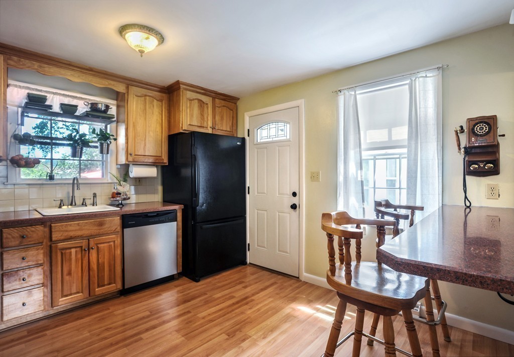 86 Edgemere Road Boston, MA 02132 - Photo 8 of 23 a kitchen with a table chairs refrigerator and microwave