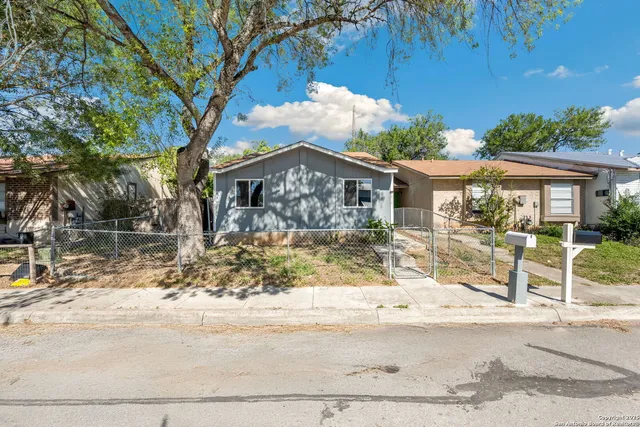 a front view of a house with a yard tree and outdoor seating