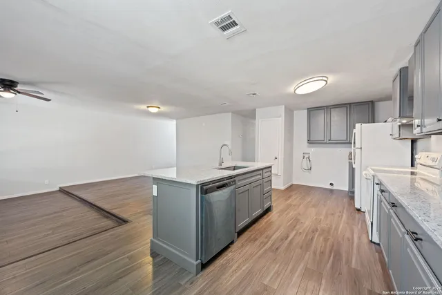 a kitchen with granite countertop a sink and a stove top oven