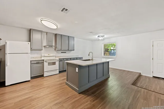 a kitchen with a white cabinets and window