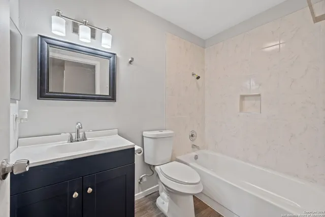 a bathroom with a toilet a sink a mirror and bathtub