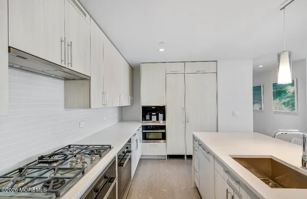 a kitchen that has a sink stainless steel appliances a counter space and cabinets