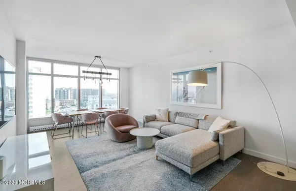 a living room with furniture and two large window