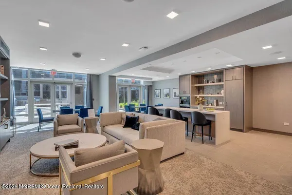 a living room with couches a coffee table and kitchen view