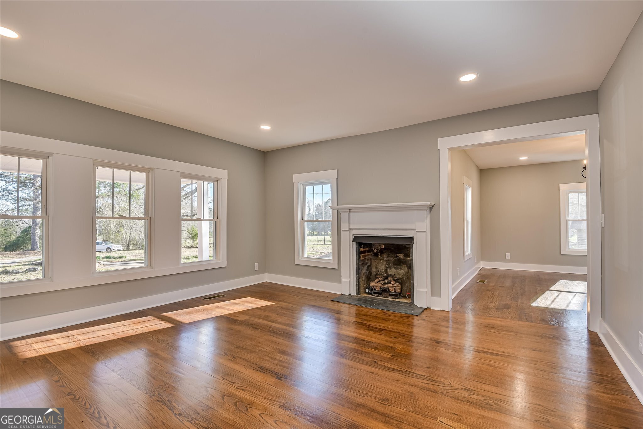 267 Garrard Road Washington, GA 30673 - Photo 23 of 74 an empty room with wooden floor fireplace and windows