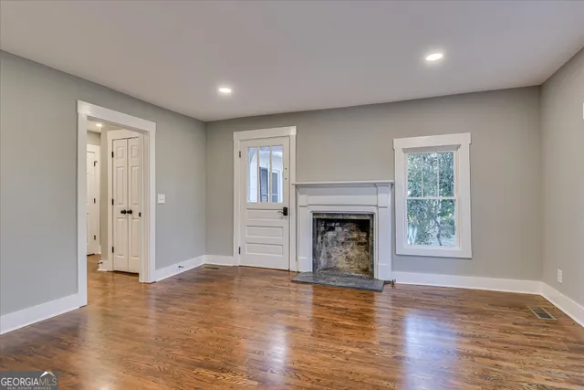 a view of a hallway with wooden floor and entryway