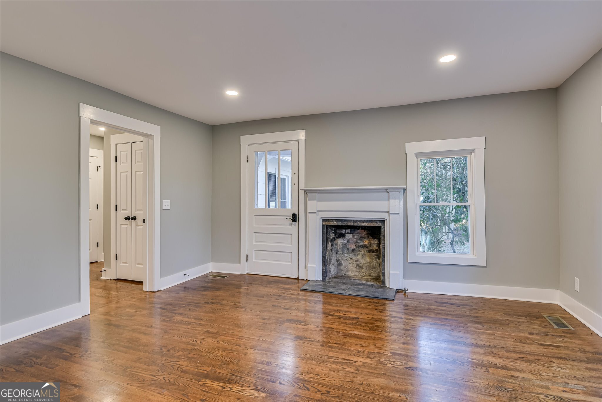 267 Garrard Road Washington, GA 30673 - Photo 32 of 74 a view of a livingroom with a fireplace wooden floor and windows