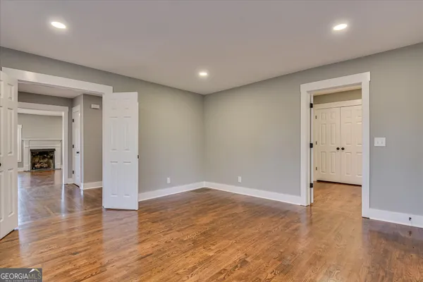 a view of an empty room with window and wooden floor