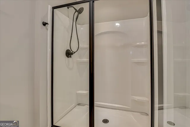 a view of an empty room with wooden floor fireplace and a window