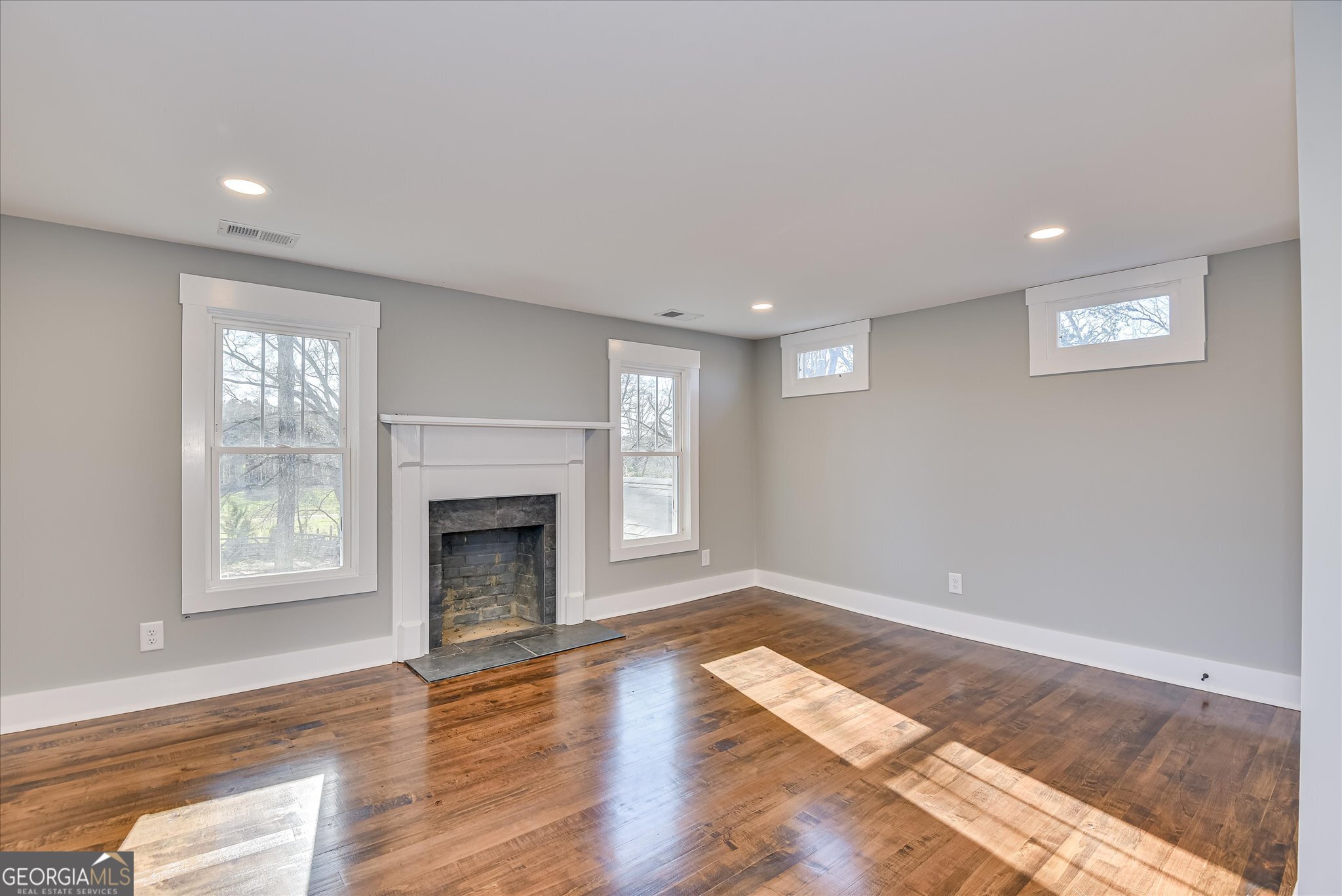 267 Garrard Road Washington, GA 30673 - Photo 51 of 74 a view of an empty room with wooden floor fireplace and a window
