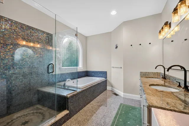 a bathroom with a tub sink and mirror