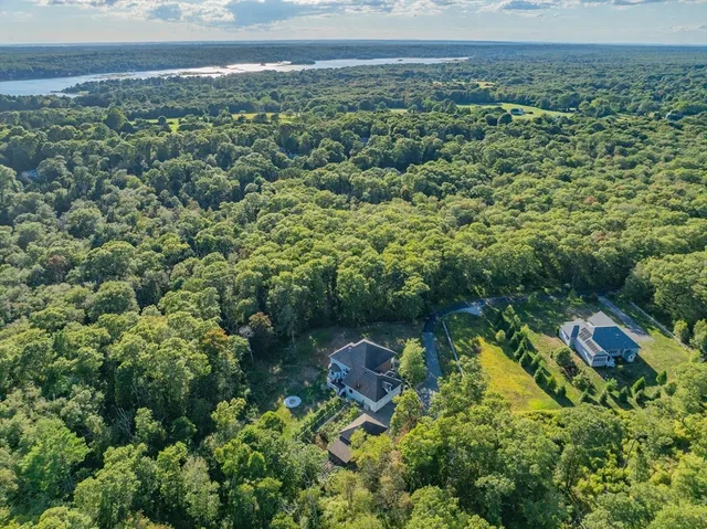 an aerial view of residential house with outdoor space and trees all around
