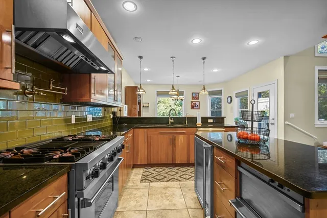 a kitchen with stainless steel appliances granite countertop a stove and a sink