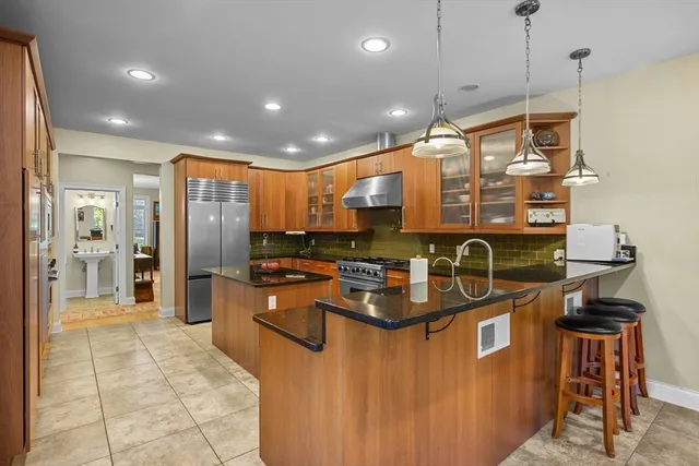 a kitchen with stainless steel appliances granite countertop a sink a stove and a refrigerator