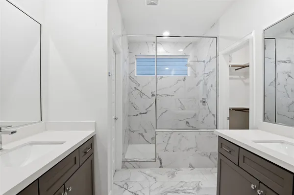 a bathroom with a shower sink and mirror