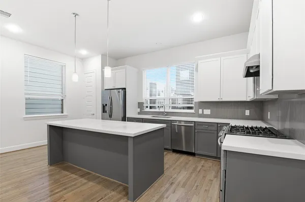 a kitchen with stainless steel appliances granite countertop a sink stove and refrigerator