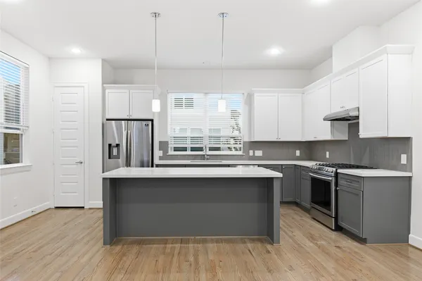 a kitchen with stainless steel appliances granite countertop a sink stove and refrigerator