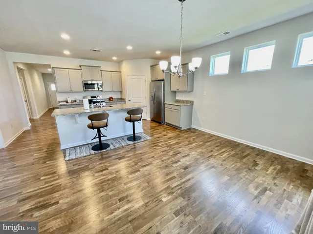 a living room with kitchen island granite countertop furniture and a chandelier